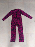 Girls full-zip long sleeve jumpsuit with swirling pink tribal print. Slim stretch fit one-piece costume, sleek full-length design, great for dance performance, cosplay and loungewear dress-up.